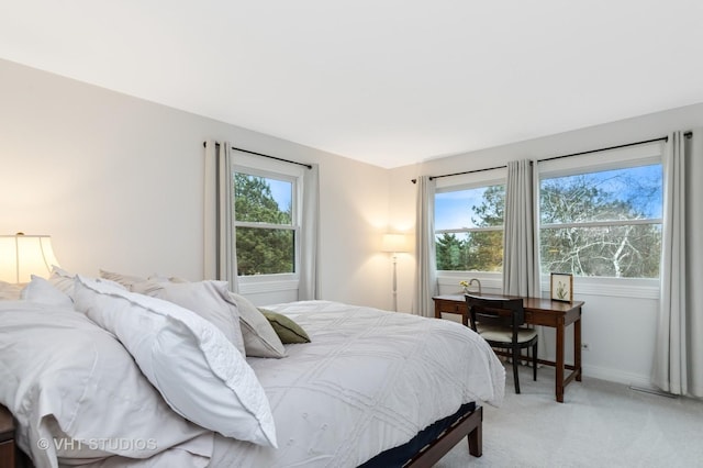 bedroom featuring light carpet and baseboards