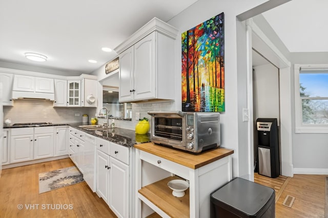 kitchen with gas cooktop, a toaster, a sink, wooden counters, and dishwasher