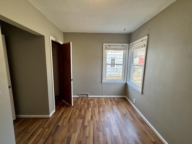 unfurnished bedroom featuring wood finished floors and baseboards