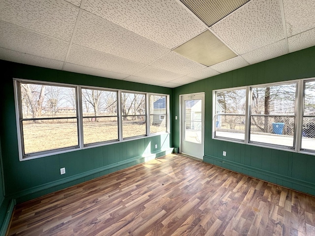 unfurnished sunroom featuring plenty of natural light and a drop ceiling