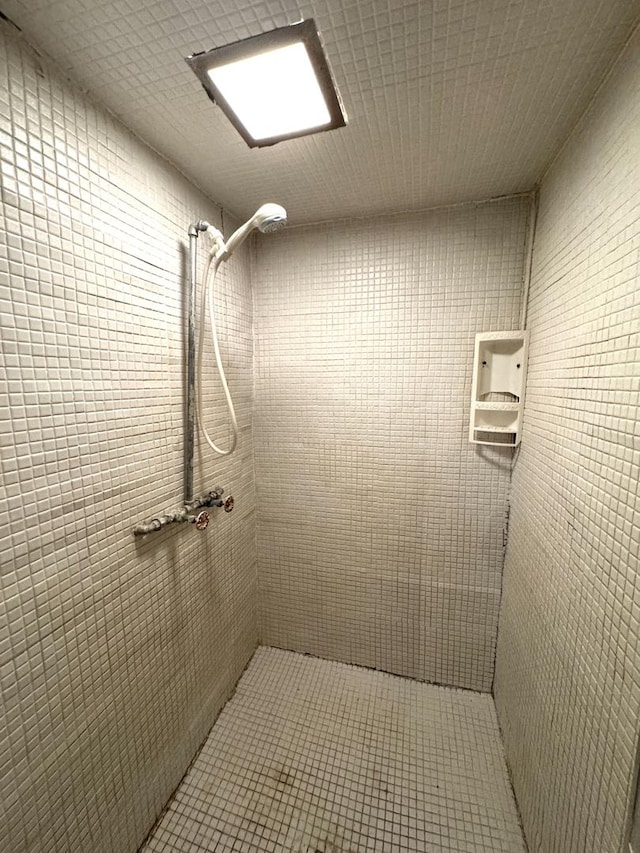 full bathroom with a tile shower and tile patterned floors