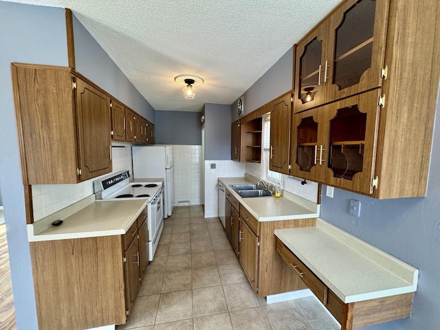 kitchen with light tile patterned floors, a textured ceiling, white appliances, light countertops, and open shelves