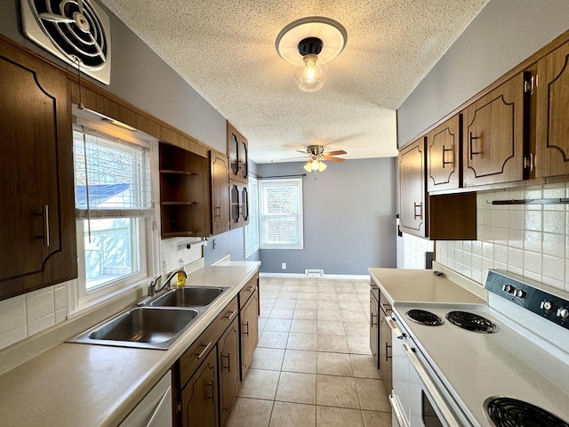 kitchen featuring white electric stove, light tile patterned floors, light countertops, a sink, and ceiling fan