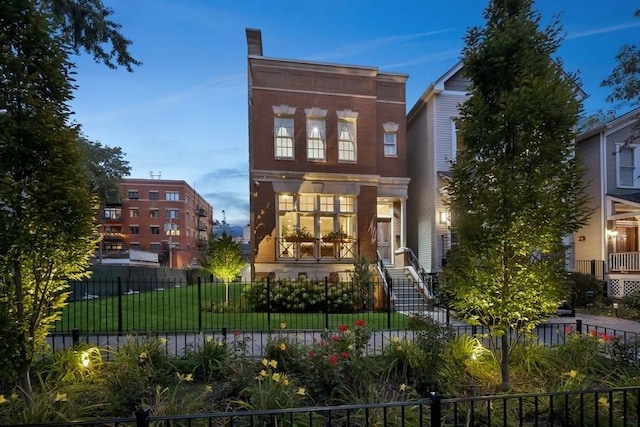 view of front of property featuring a fenced front yard and brick siding