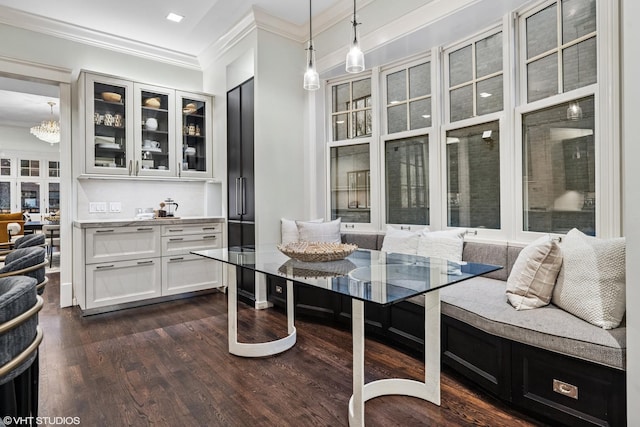 interior space featuring dark wood-type flooring, breakfast area, and crown molding