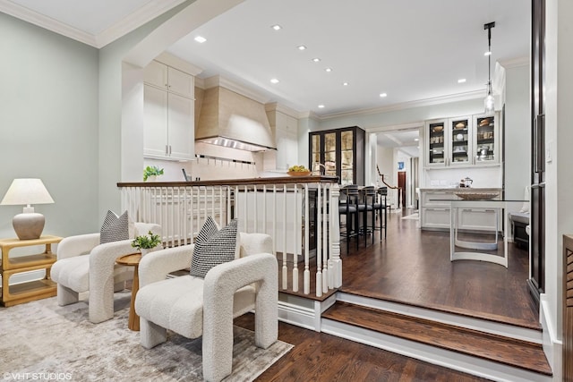 sitting room featuring dark wood-style floors, ornamental molding, arched walkways, and recessed lighting