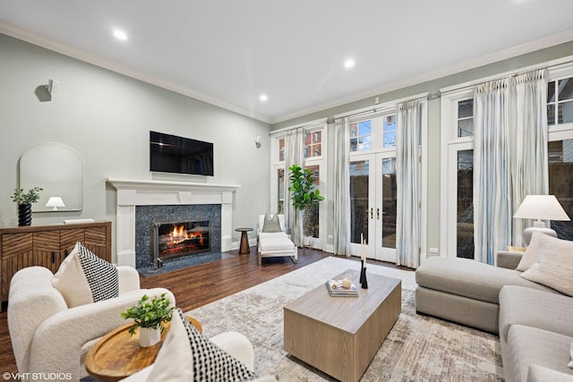 living area featuring a high end fireplace, ornamental molding, wood finished floors, french doors, and recessed lighting