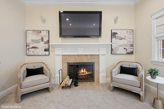 sitting room with baseboards, carpet, a fireplace, and crown molding