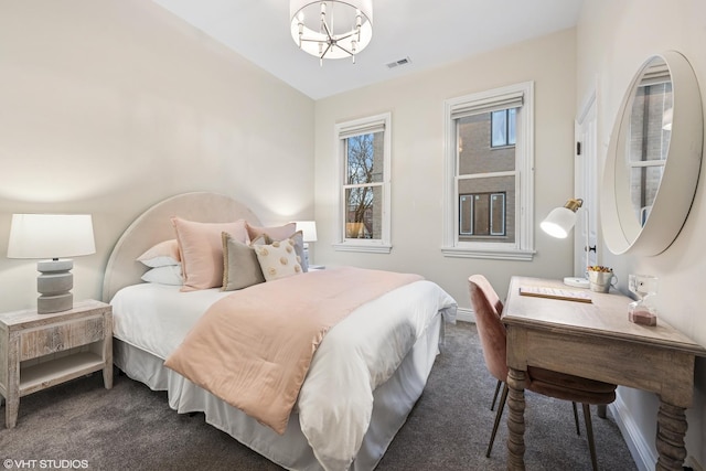 bedroom with an inviting chandelier, visible vents, and dark colored carpet