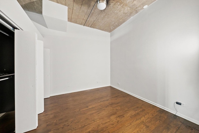 empty room featuring baseboards and wood finished floors