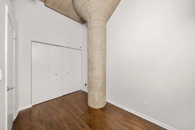 unfurnished bedroom featuring a closet, wood finished floors, and baseboards