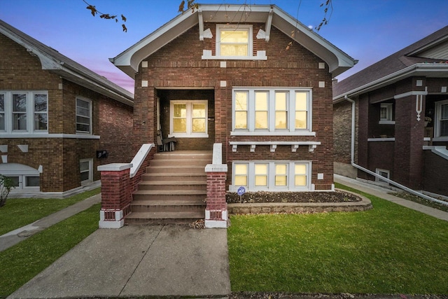 view of front of home featuring a front yard and brick siding