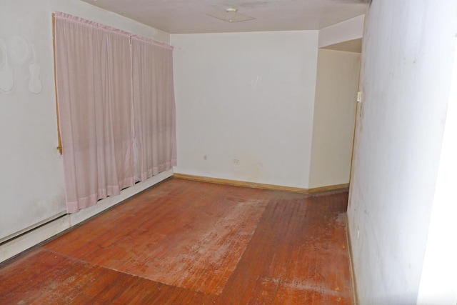 spare room featuring baseboards and hardwood / wood-style floors