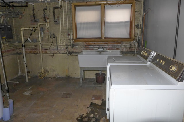 clothes washing area with laundry area, washer and clothes dryer, and a sink