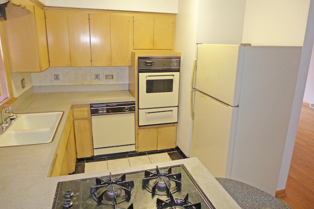 kitchen featuring light brown cabinets, white appliances, a sink, light countertops, and a warming drawer