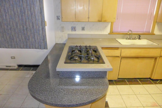 kitchen featuring light tile patterned floors, black gas stovetop, and a sink