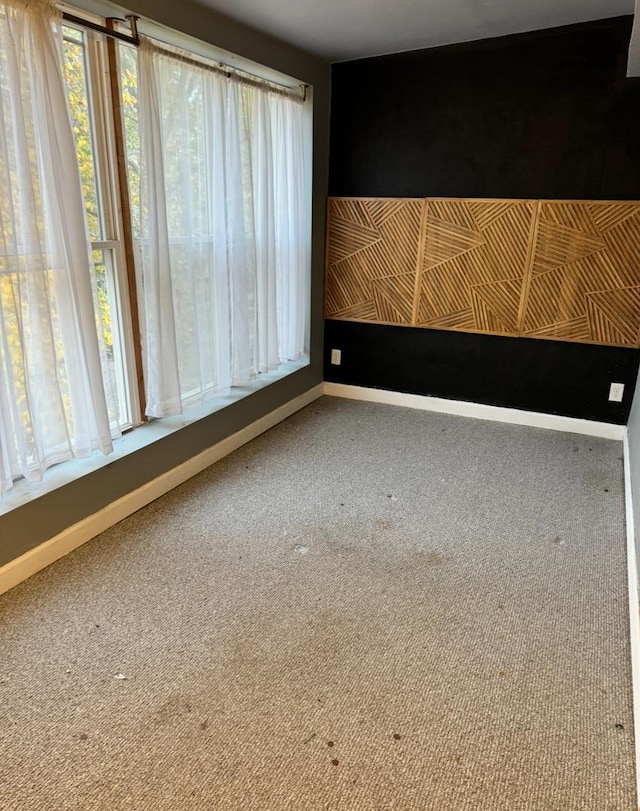 carpeted empty room featuring baseboards