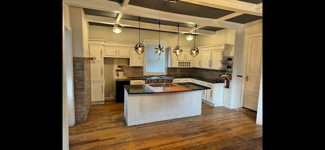 kitchen with white cabinets, dark wood finished floors, and an island with sink