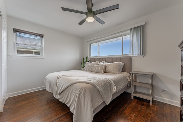 bedroom featuring multiple windows, baseboards, and wood finished floors