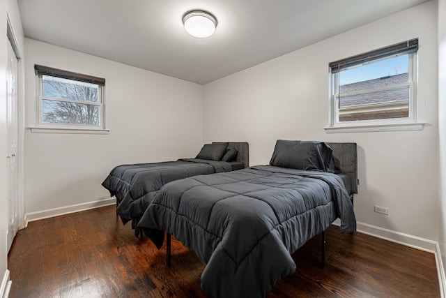 bedroom featuring multiple windows, baseboards, and wood finished floors