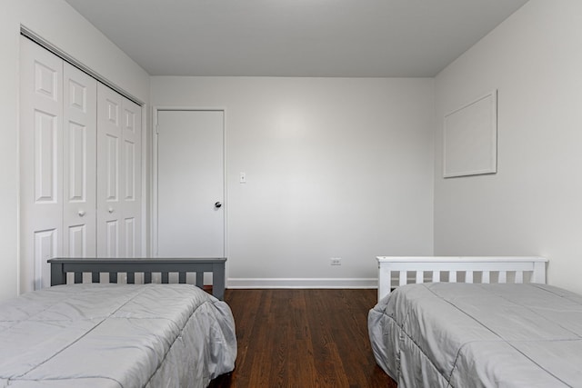 bedroom featuring a closet, baseboards, and wood finished floors