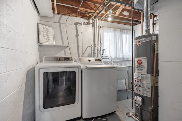 laundry area with independent washer and dryer, laundry area, gas water heater, and concrete block wall