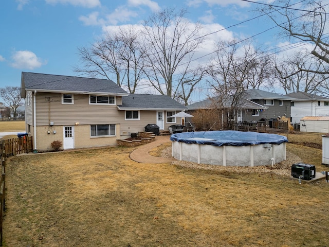 view of swimming pool with a covered pool, a lawn, area for grilling, and fence