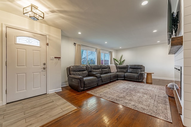 living room featuring baseboards, wood finished floors, and recessed lighting