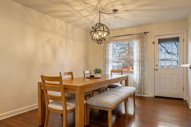 dining room with a notable chandelier, dark wood-type flooring, and baseboards