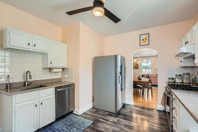 kitchen featuring a ceiling fan, appliances with stainless steel finishes, arched walkways, a sink, and under cabinet range hood