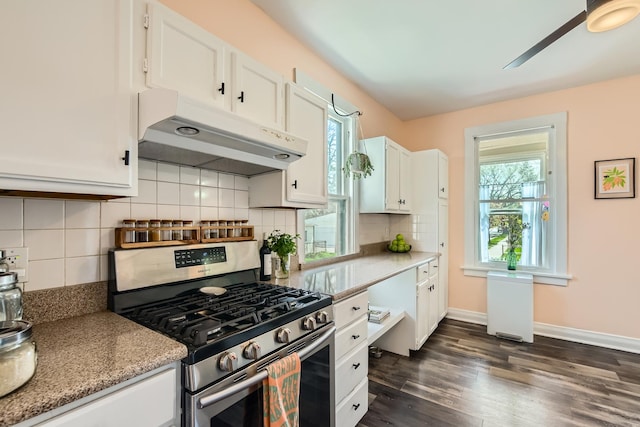 kitchen featuring gas range, white cabinetry, baseboards, dark wood-type flooring, and under cabinet range hood