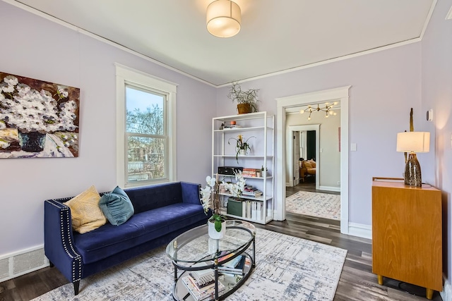 living room with visible vents, crown molding, wood finished floors, baseboards, and an inviting chandelier