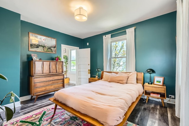 bedroom with baseboards and dark wood-style floors