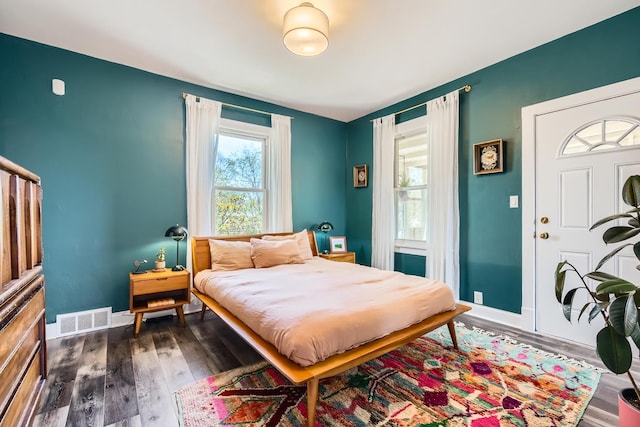 bedroom with baseboards, dark wood-type flooring, and visible vents