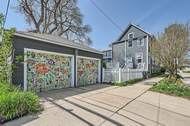 view of side of property featuring a garage and fence