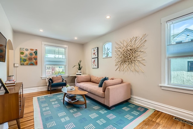 living room featuring visible vents, wood finished floors, baseboards, recessed lighting, and arched walkways