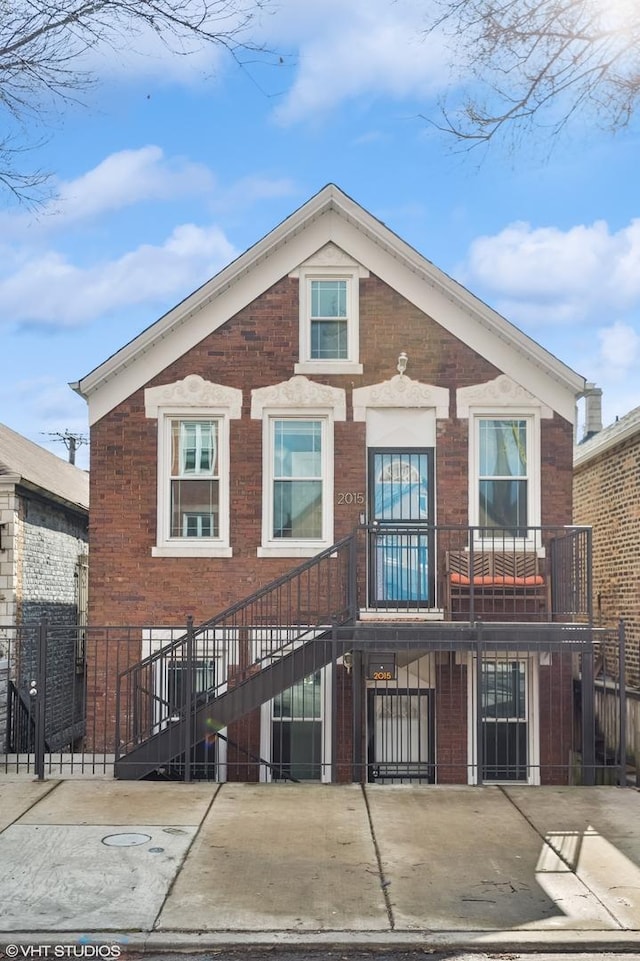 view of front of house featuring fence and brick siding