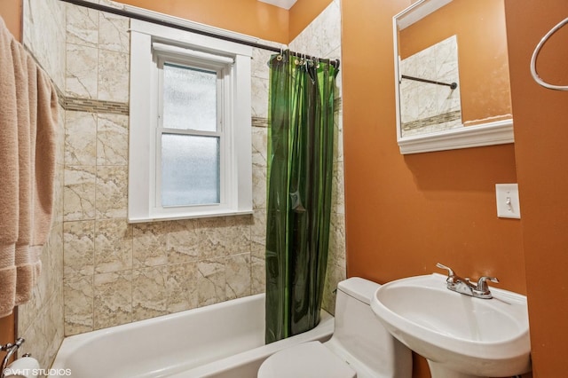 full bath with a sink, toilet, and shower / tub combo with curtain