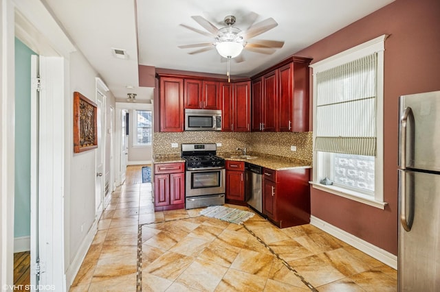 kitchen with reddish brown cabinets, tasteful backsplash, visible vents, and stainless steel appliances