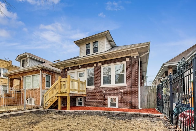 rear view of house featuring brick siding and fence