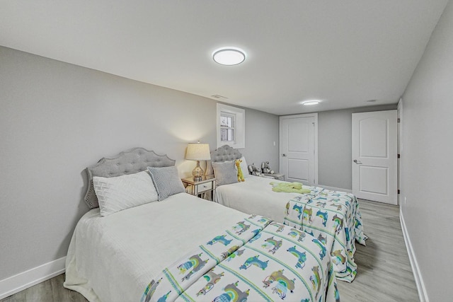 bedroom with baseboards and wood finished floors