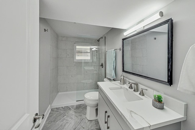 full bath featuring marble finish floor, vanity, a tile shower, and toilet