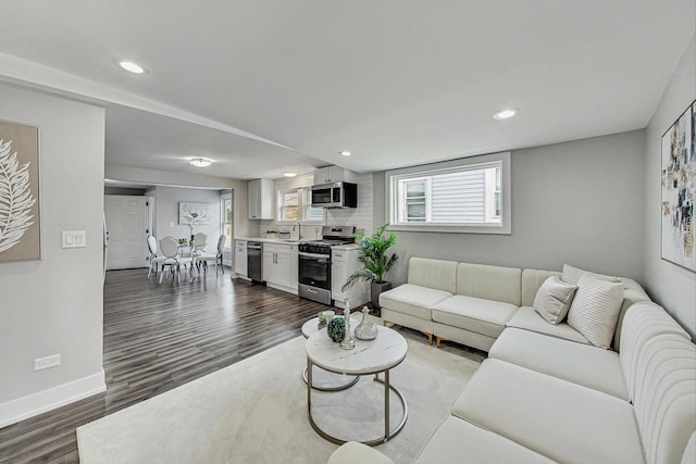 living room with a wealth of natural light, dark wood-style flooring, baseboards, and recessed lighting