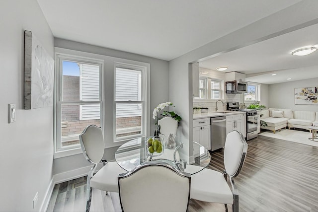 dining space featuring baseboards and wood finished floors