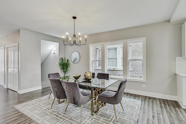 dining area with an inviting chandelier, baseboards, and wood finished floors