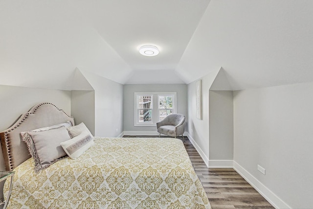 bedroom featuring lofted ceiling, wood finished floors, and baseboards