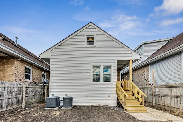 rear view of house with cooling unit and fence