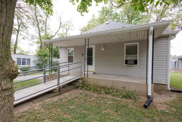 view of front facade featuring covered porch and a shingled roof