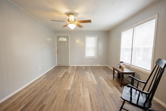 foyer featuring visible vents, a ceiling fan, light wood-style flooring, and baseboards