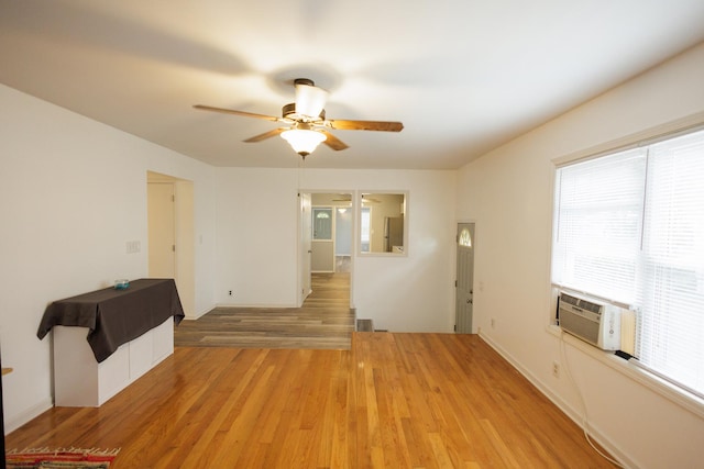 spare room featuring ceiling fan, cooling unit, and light wood-style floors